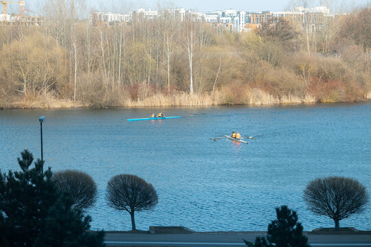 Rowers training on a wide city river with urban skyline
