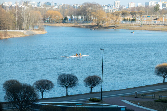 Rowers training on a wide city river with urban skyline