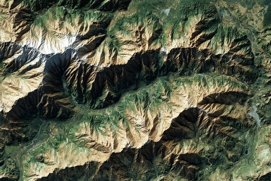 Detailed aerial satellite view of rugged mountain range with deep valleys and arid terrain