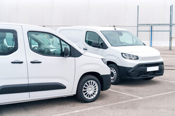 White delivery vans are parked in rows. Commercial fleet of vehicles © scharfsinn86
