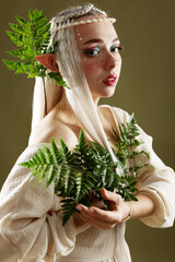 Naklejka premium Beautiful elf girl with floral decor on dark olive background