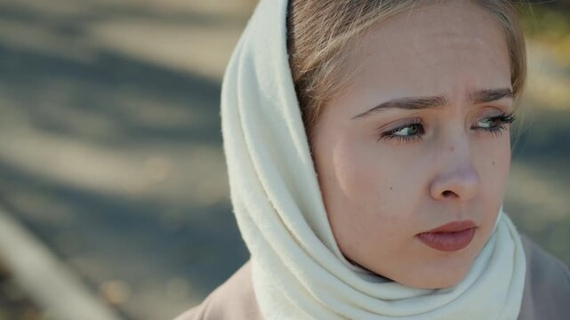 Young caucasian woman scarf determined gaze, activist rehearsal, job interview practice, guardian lookout, survivor reflection crisp daylight, sharp profile, autumn pavement, focused eyes, set jaw,