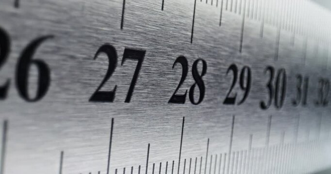 Slow Pan Over Metal Ruler. Smooth slow movement across extreme close-up of metallic ruler with black numbers and brushed surface.