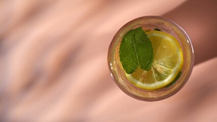Top view of a refreshing drink with lemon slice, mint leaf and sparkling water bubbles. Concepts of summer drink, themes for bars, cafes, and restaurants, refreshment, beverage, health. © kinomaster
