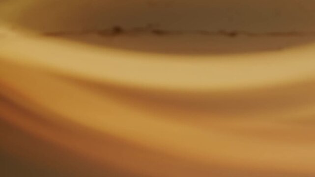 An abstract microstock video featuring soft, warm orange light leaks and subtle lens flares dancing across a dark, defocused background, creating a nostalgic, dreamlike aesthetic perfect for cinematic