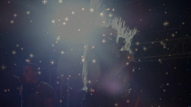 Singer performing into microphone on cue, spotlight and star overlay intensifying, softening forms