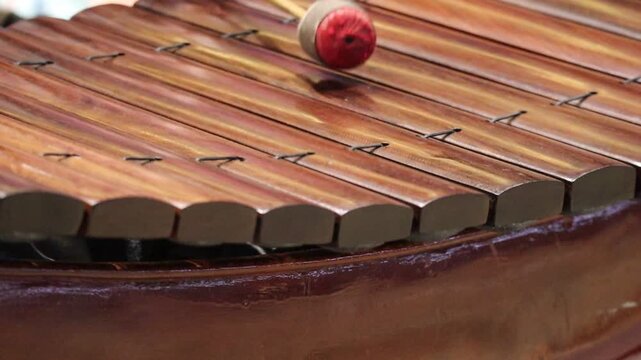 Close Up of Musician's Hands Playing a Traditional Thai Ranat Ek Wooden Xylophone with Mallets.