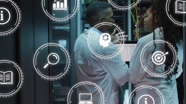 Two techs pointing monitor, fixing rack in data center while icons scrolling partly blocking view