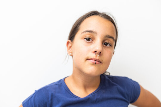Closeup of a young teen girl's visage with piercing hanging from her lip
