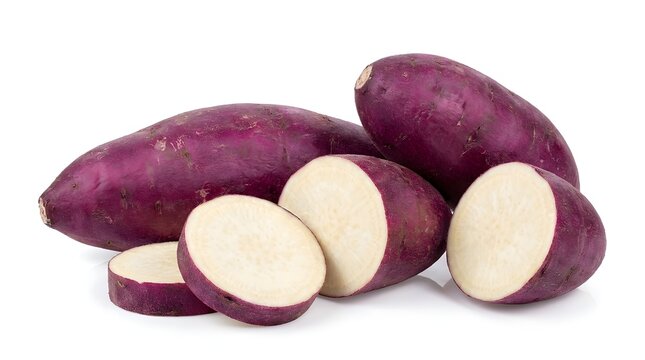 Fresh organic purple sweet potatoes with white flesh isolated on white background. Whole and sliced Japanese sweet potatoes or yams. Healthy vegan root vegetable for cooking and nutritious diet.