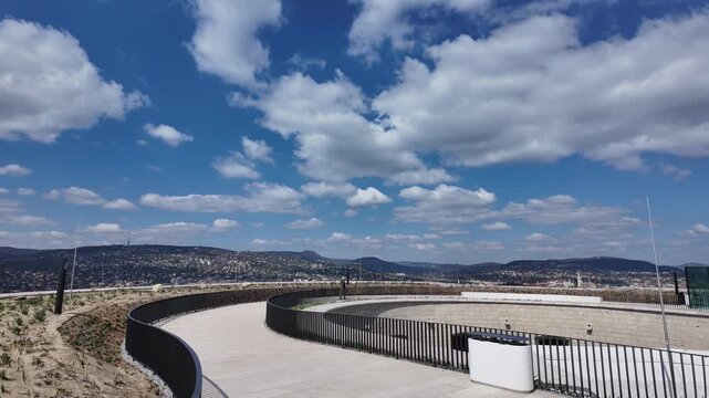 Cinematic left to right pan of the Citadella terrace in Budapest. An unrecognizable tourist walks in the distance. Slow motion.