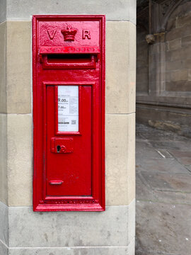 Shrewsbury, England, UK - March 31, 2026; Queen Victoria VR cypher on red wall mounted post box with schedule
