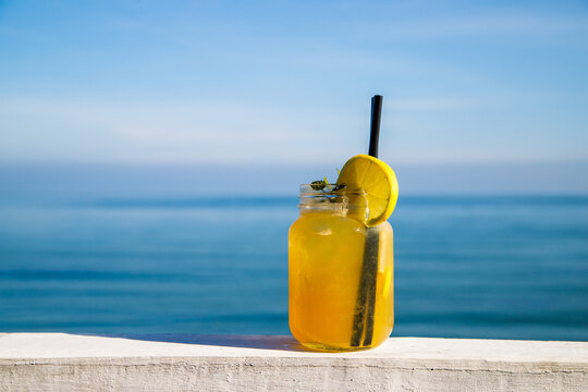 Fresh lemonade cocktail with lemon slice on seaside background
