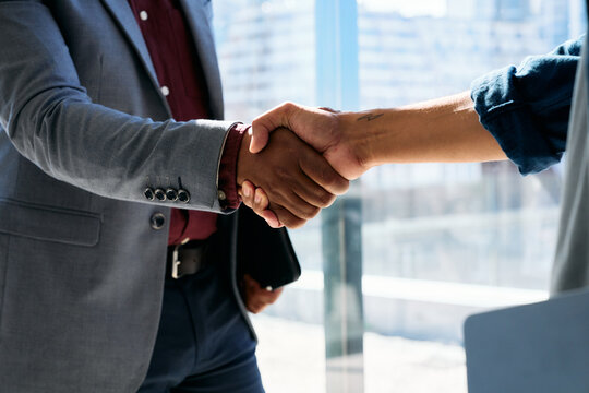 Closeup of business people shaking hands in boardroom at office during daytime