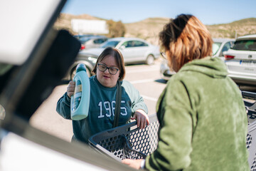 Woman with down syndrome putting detergent in car © Cristian Blázquez