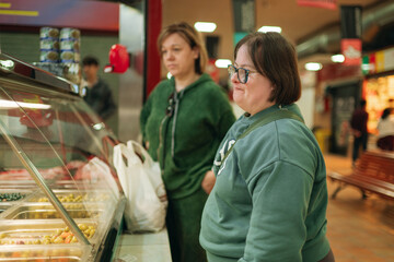 Obraz premium Young woman with down syndrome shopping at market