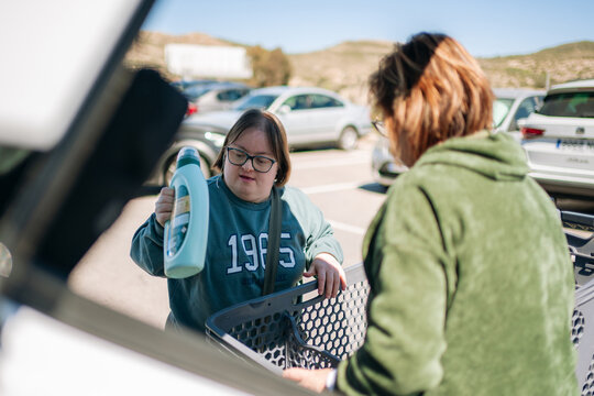 Woman with down syndrome putting detergent in car