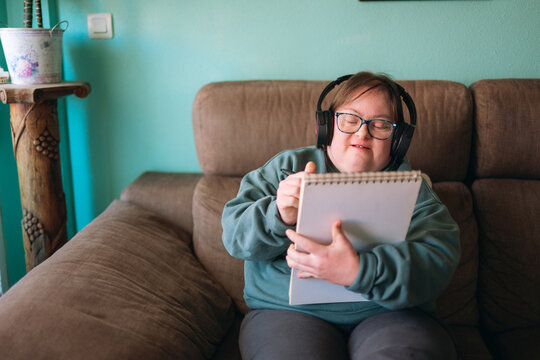 Young woman with down syndrome drawing and listening music