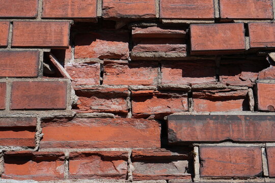 Damaged Red Brick Wall Texture with Broken Masonry and Decay