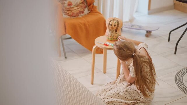 Young girl seated on floor arranging pumpkin pie, pretend snack time with doll and skateboard in background, sunlit room, polka dress with braid, thoughtful candid mood, warm domestic scene capturing