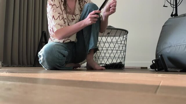 Owner tries to brush maine coon cat but it moves away from grooming on floor. Large fluffy feline resists combing and leaves during care routine indoors. Pet behavior independence and