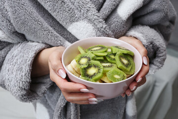Woman holding bowl of kiwi and banana. Fresh fruit snack in hands. Healthy eating concept. Natural vitamins meal. Simple home lifestyle scene. Clean breakfast idea for wellness routine. © Paweł Michałowski