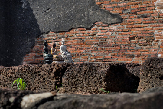 Dark stone prang with a dramatic arched opening at Ayutthaya Thailand, photographed in shadow to reveal textured ancient masonry and mystery.