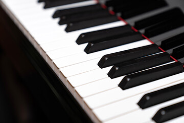 Naklejka premium Close up of piano keys in black and white, abstract musical background for classical, jazz, and modern compositions, perfect for music education, concert promotion, and creative design projects 