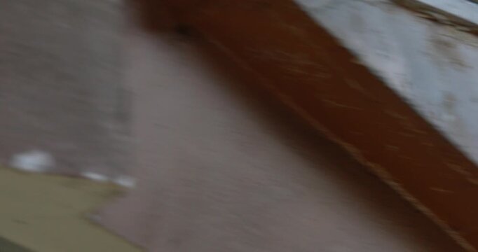 Close-up shot of a person's legs rapidly running up a flight of dusty, unfinished concrete stairs in what appears to be a construction site or an abandoned building.

