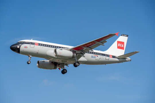 British Airways Airbus A319 in Retro BEA Heritage Livery Landing Against Blue Sky