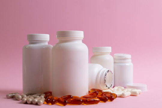 Vitamins On Neutral Background. Assorted Supplement Bottles With Capsules On Plain Backdrop