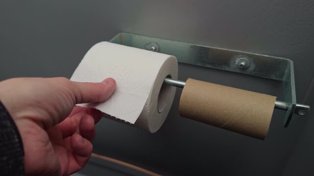 Toilet roll replacement. Caregiver gently replacing toilet paper roll with careful attention in daily routine