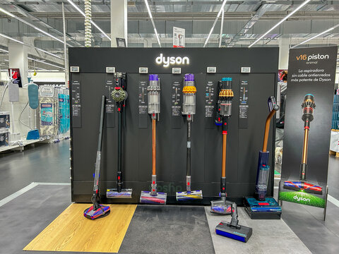 Mutilva, Spain - April 11, 2026. A display of Dyson cordless vacuum cleaners inside a MediaMarkt electronics and technology store. The products are arranged vertically on a black panel with 