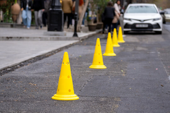 Road with cones marking a closed or restricted section, indicating traffic control, construction work, safety precautions, and temporary urban road management.