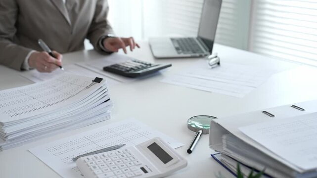 Businesswoman hands organizing stack of papers with binder clips, working on financial documents and official reports in office. Audit and taxes concept