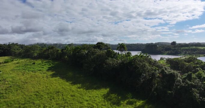 4K aerial drone view of Alto Tiete reservoir in Brazil, showing water storage, rural landscape, forests and agricultural fields under blue sky