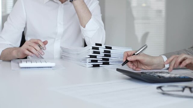 Businesspeople analyzing financial documents and tax forms, planning business strategy, making financial decisions. Audit and taxes in business