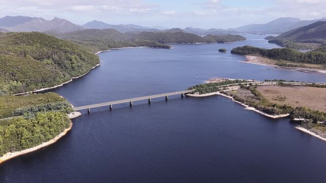 Cars on Bradshaw bridge crossing lake Burbury Lyell Highway in Tasmania mountains.