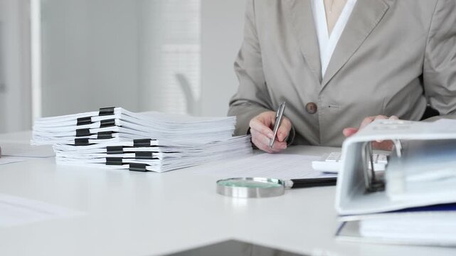 Businesswoman hands organizing stack of papers with binder clips, working on financial documents and official reports in office. Audit and taxes concept