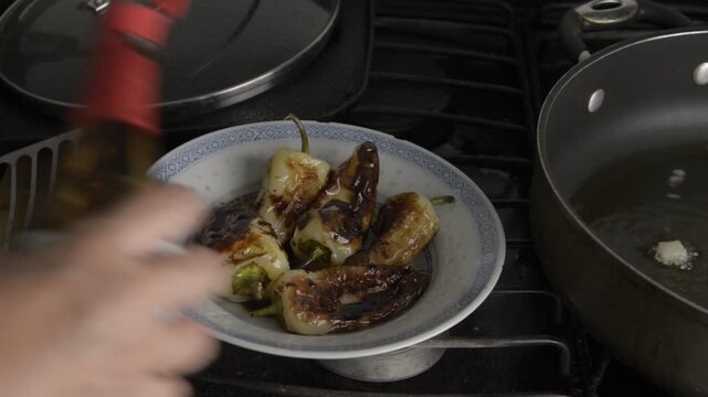 chiles fritos o asados en sarten SALTEADOS en aceite en una cocina de casa, para usarse de guarnicion o acompa&ntilde;ar carnes pescados o pollo como parte de la costumbre Mexicana.