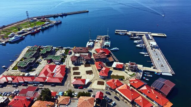Visitors can stroll through Nesebar Old Town overlooking the Black Sea, enjoying the view of boats at the dock and the unique buildings with red roofs.