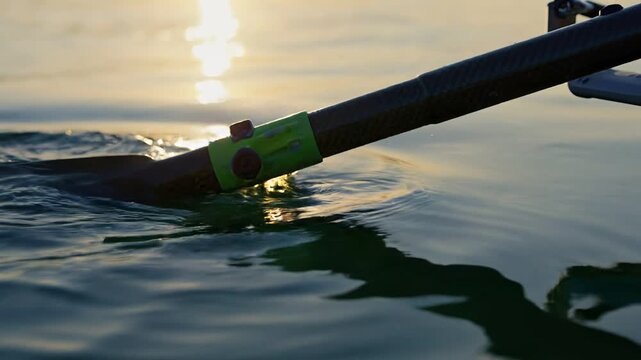 Close Up Rowing Oar Dripping Water at Sunrise.
