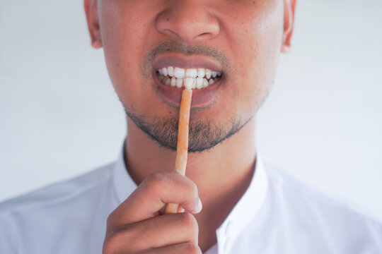 Man holding miswak for traditional oral hygiene