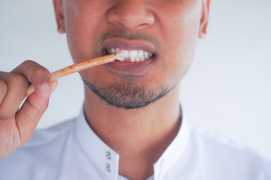 Man holding miswak for traditional oral hygiene