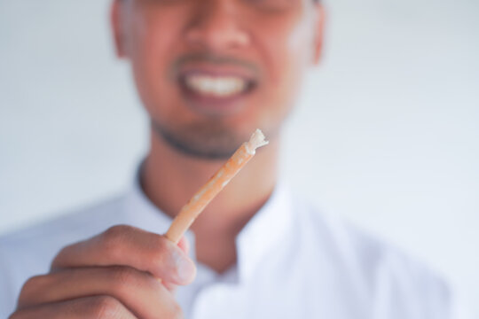 Man holding miswak for traditional oral hygiene