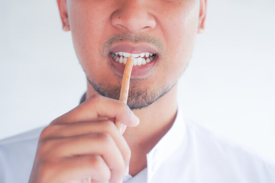 Man holding miswak for traditional oral hygiene