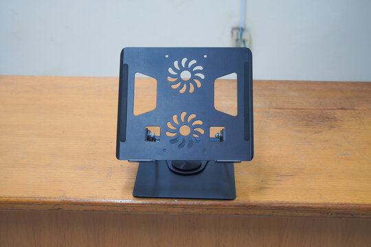 Adjustable aluminum laptop stand on wooden table