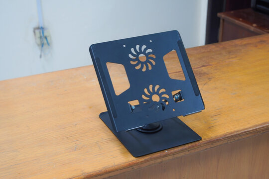 Adjustable aluminum laptop stand on wooden table