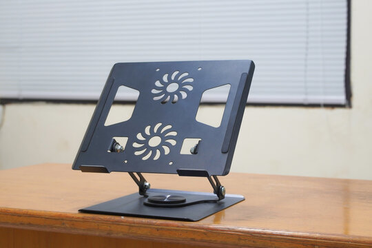 Adjustable aluminum laptop stand on wooden table
