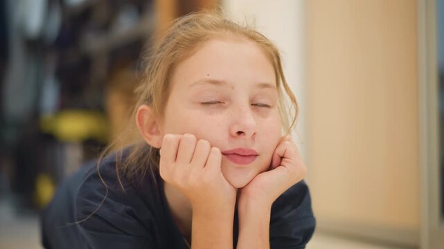 Freckled white girl sitting peacefully in cozy kitchen scene. Young girl with fair skin and freckles relaxes in warm kitchen setting while imagining cooking and enjoying homely environment